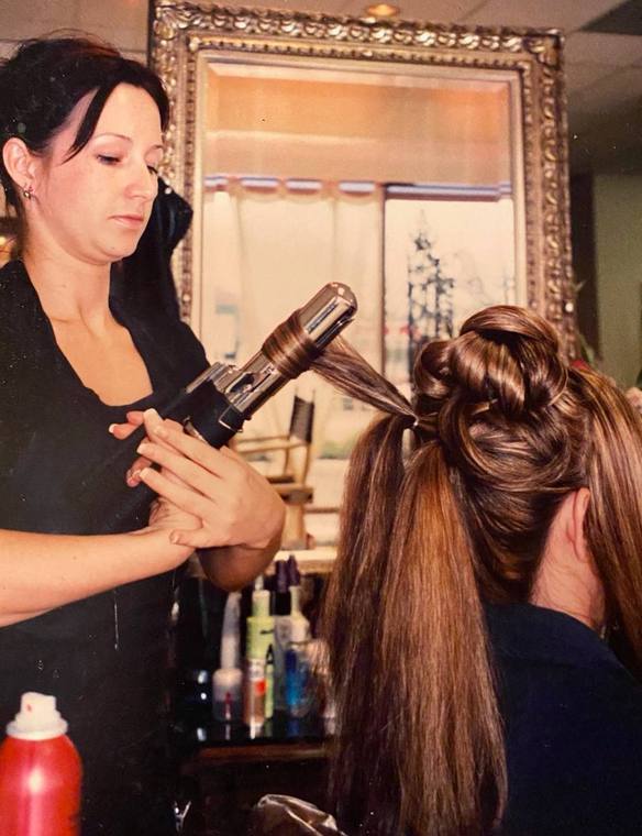 Christal setting a formal updo with a curling iron
