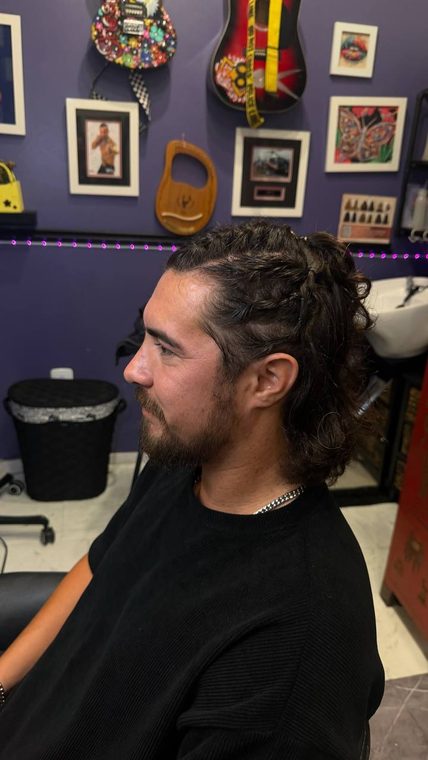 A men's cut with a braided top knot and tapered sides, by Christal B.